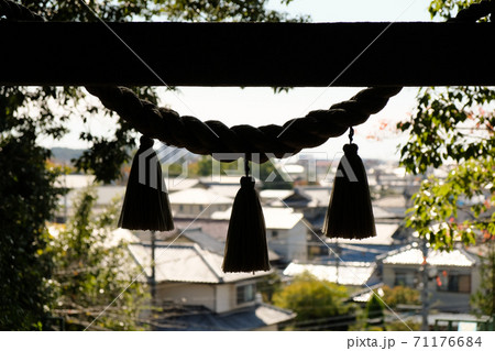 神社の注連縄と家並み 71176684