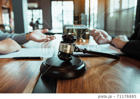 Legal advisor is explaining the offense under the law in the book at office. Legal advisor is explaining the offense under the law in the book at office. 71176885