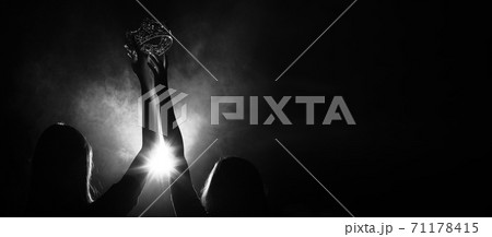 Silhouette abstract of two hands try to reach Diamond Crown as Miss Beauty Queen Pageant Contest as final competition, finale winner moment. Backlit smoke low exposure dark background copy space Silhouette abstract of two hands try to reach Diamond Crown as Miss Beauty Queen Pageant Contest as final competition, finale winner moment. Backlit smoke low exposure dark background copy space 71178415
