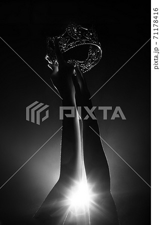 Silhouette abstract of two hands try to reach Diamond Crown as Miss Beauty Queen Pageant Contest as final competition, finale winner moment. Backlit smoke low exposure dark background copy space Silhouette abstract of two hands try to reach Diamond Crown as Miss Beauty Queen Pageant Contest as final competition, finale winner moment. Backlit smoke low exposure dark background copy space 71178416