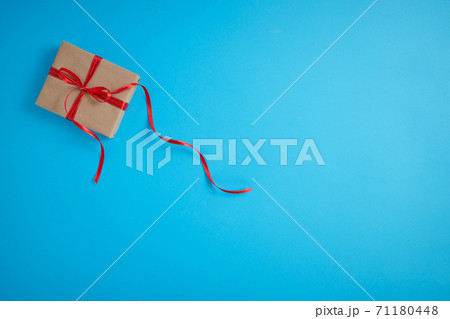 Gift box with a red bow on a blue Gift box with a red bow on a blue 71180448