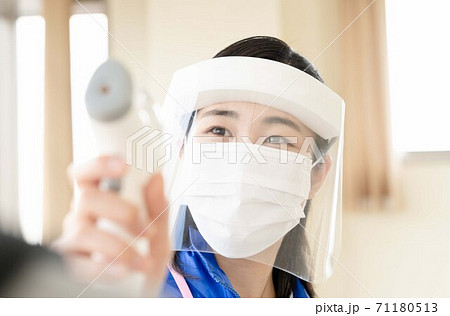 体温を測る女性スタッフ【非接触体温計】 体温を測る女性スタッフ【非接触体温計】 71180513