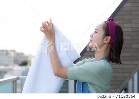 バルコニーで洗濯物を干す主婦 バルコニーで洗濯物を干す主婦 71180564