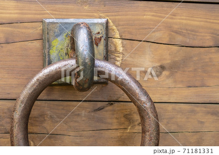 Wooden old cracked shabby plank with rusty door ring close-up. Copspace. Broken mount. Wooden old cracked shabby plank with rusty door ring close-up. Copspace. Broken mount. 71181331