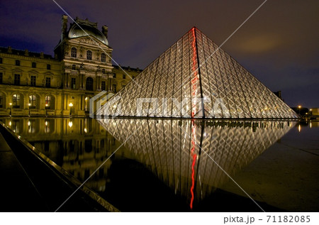 ライトアップが反射するルーブル美術館のピラミッドの写真素材