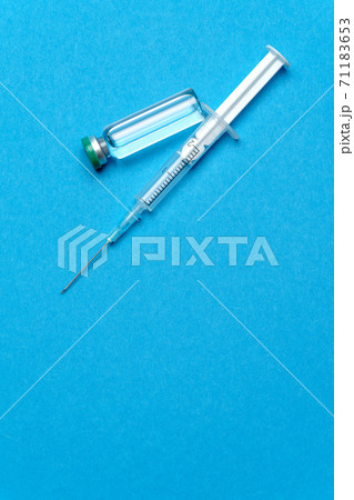 Syringe and ampoules with medicines or vaccine over blue background Syringe and ampoules with medicines or vaccine over blue background 71183653