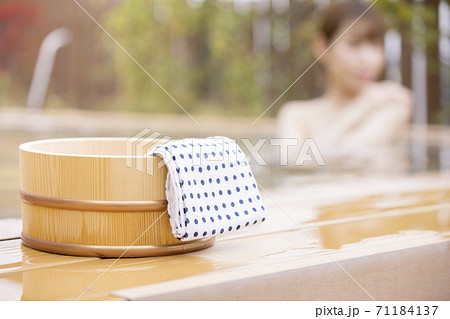 風呂桶と露天風呂に入る女性 温泉イメージ GoToトラベルキャンペーン 風呂桶と露天風呂に入る女性 温泉イメージ GoToトラベルキャンペーン 71184137