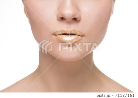 Gold Paint drips from the lips, golden liquid drops on beautiful model girl's mouth. Beauty woman face makeup close up Gold Paint drips from the lips, golden liquid drops on beautiful model girl's mouth. Beauty woman face makeup close up 71187161
