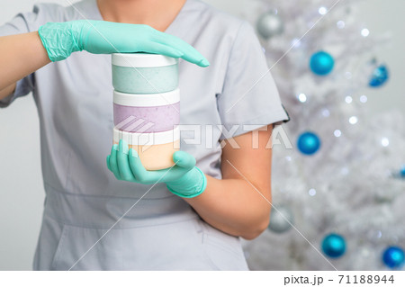 Female cosmetologist holding tree jars Female cosmetologist holding tree jars 71188944