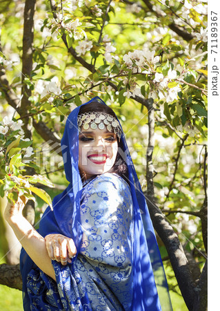 young pretty indian girl in jewelry and veil posing cheerful happy smiling in green park, lifestyle people concept 71189367