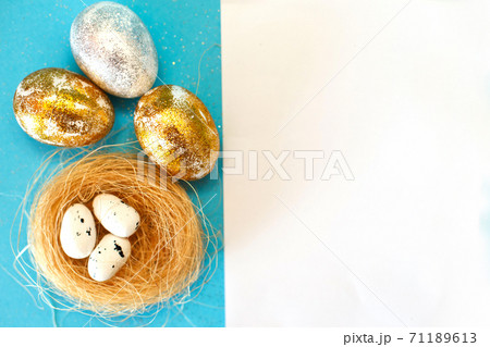 Gold and silver Easter eggs with nest on a blue background. Easter concept. Happy Easter. Copy space 71189613