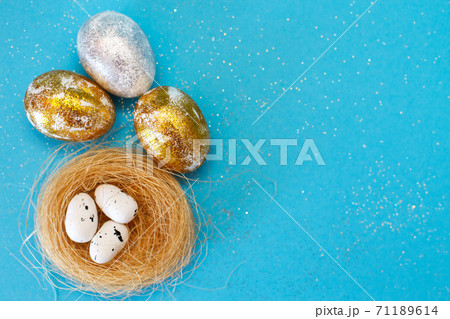 Gold and silver Easter eggs with nest on a blue background. Easter concept. Happy Easter. Copy space 71189614