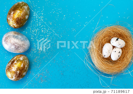 Gold and silver Easter eggs with nest on a blue background. Easter concept. Happy Easter. Copy space 71189617