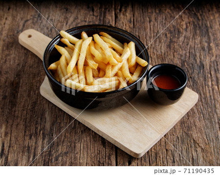French fries with ketchup on a dark wood background. fastfood snack. French fries with ketchup on a dark wood background. fastfood snack. 71190435