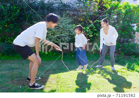 お庭で縄跳びをして遊ぶ仲良しファミリー  71191562