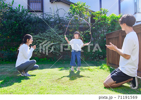 お庭で縄跳びをして遊ぶ仲良しファミリー  71191569