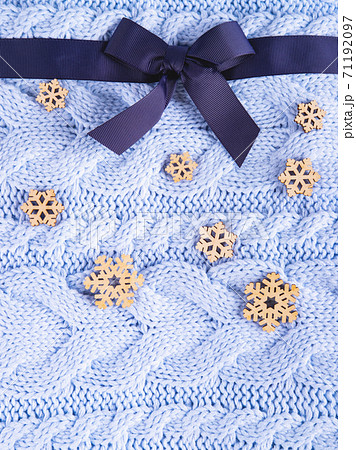Beautiful wool knitted background with the ribbon and wooden snowflakes. 71192097
