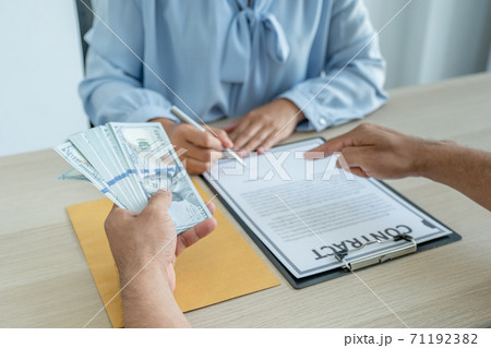 Businessman hand who offer bribes money to government officials for signing in a contract of business project, concept of corruption and anti-bribery Businessman hand who offer bribes money to government officials for signing in a contract of business project, concept of corruption and anti-bribery 71192382