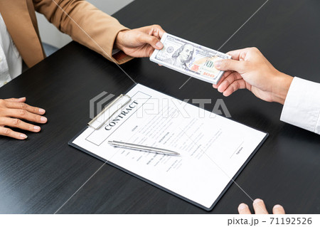 Businessmen give money to bribe partner secretly passing money, bribery and corruption concepts. 71192526