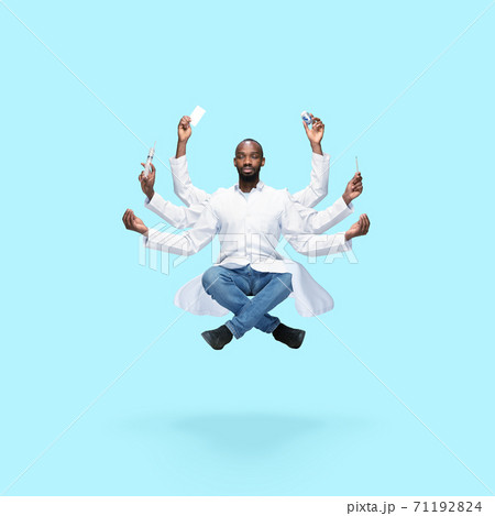Handsome multi-armed doctor levitating isolated on blue studio background with equipment 71192824