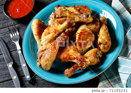 Spicy chicken drumsticks with ketchup and mustard 71193231