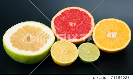 cut pieces of different citrus fruits on dark background 71194028