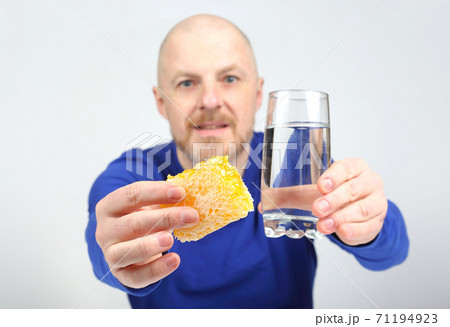 the man offers to eat comb honey and a glass of water. Healthy diet 71194923