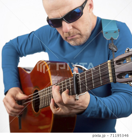 man plays the classical guitar on a white background. musical creativity. string musical instrument man plays the classical guitar on a white background. musical creativity. string musical instrument 71195346
