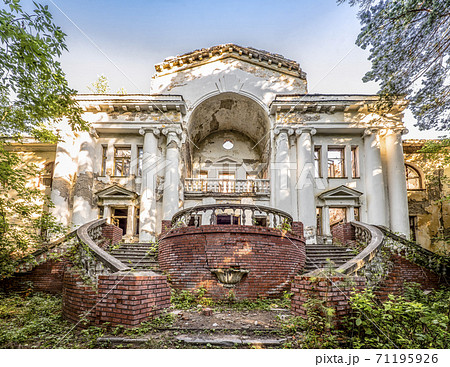 Abandoned dilapidated building in old park. Sweeping staircases, columns and a balustrade 71195926