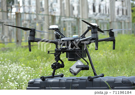 Quadcopter placed on a box before launching, blurred power lines on a background 71196184