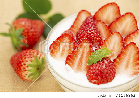 麻布を敷きガラスの器に入れミントを添えたいちごたっぷりのイチゴヨーグルト 71196862