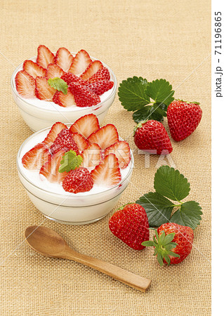 麻布を敷きガラスの器に入れミントを添えたいちごたっぷりのイチゴヨーグルト 71196865