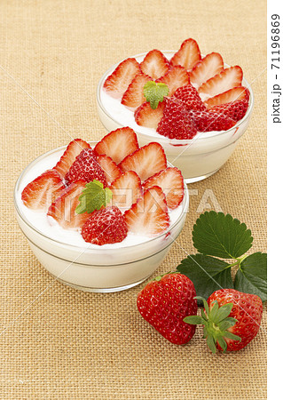 麻布を敷きガラスの器に入れミントを添えたいちごたっぷりのイチゴヨーグルト 71196869