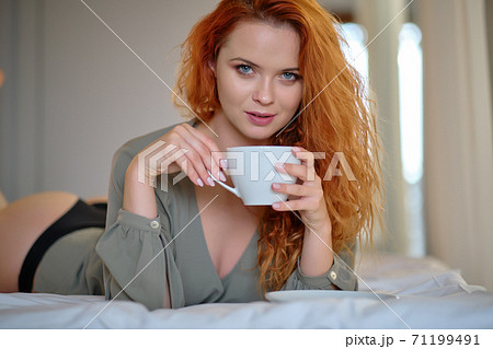 Beautiful young woman with cup of coffee at home 71199491
