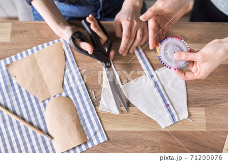 Sewing process close-up. Hands of woman and daughter sewing Sewing process close-up. Hands of woman and daughter sewing 71200976