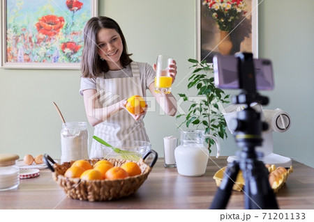 Girl teenager food blogger recording recipe for cooking orange pancakes 71201133