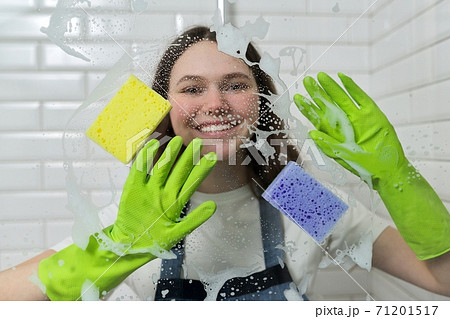 Bathroom cleaning, teenager girl washing shower glass with foam and sponges 71201517