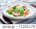 Salad with ham and arugula on white plate 71203179