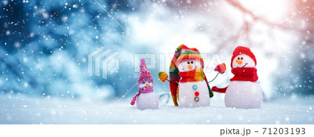 Little knitted snowmen on soft snow on blue background Little knitted snowmen on soft snow on blue background 71203193