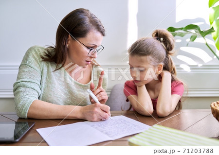 Mother and daughter child study together at home Mother and daughter child study together at home 71203788