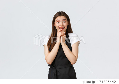 Small business, employees and coffee shop concept. Excited happy saleswoman looking temptation and rejoice at product. Cheerful coffee worker hear good news amused Small business, employees and coffee shop concept. Excited happy saleswoman looking temptation and rejoice at product. Cheerful coffee worker hear good news amused 71205442