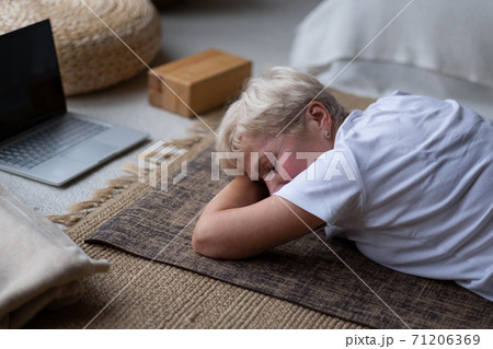 woman relaxes in yoga asana Makarasana or crocodile pose during online lesson 71206369