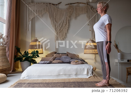 Senior woman working out indoors standing in Tadasana, Mountain Pose 71206392