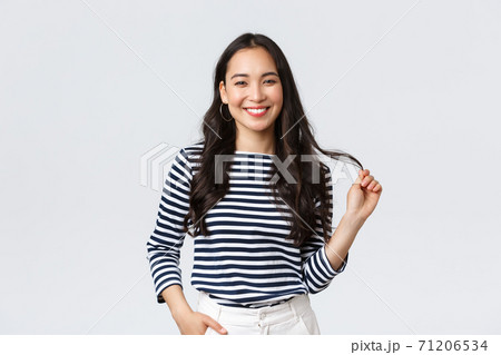 Lifestyle, people emotions and casual concept. Stylish beautiful smiling asian woman touching hair strand, made new haircut or bought good haircare product, standing white background 71206534