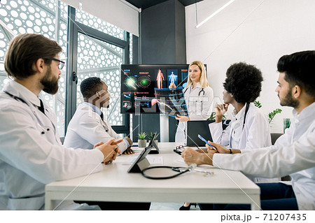 Medicine, continuing education concept. Caucasian blond woman, experienced and competent doctor, showing a presentation and speaking about new diagnostics and treatment in a seminar for colleagues Medicine, continuing education concept. Caucasian blond woman, experienced and competent doctor, showing a presentation and speaking about new diagnostics and treatment in a seminar for colleagues 71207435