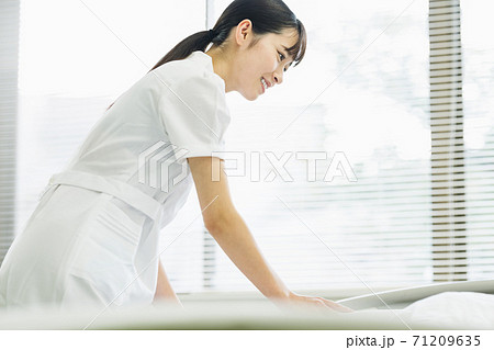 病室の布団をかける看護師 71209635