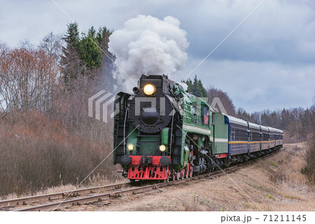 Steam train moves at autumn day time. 71211145