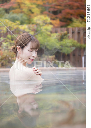紅葉バックにのんびり露天風呂に入る若い女性 紅葉バックにのんびり露天風呂に入る若い女性 71213661