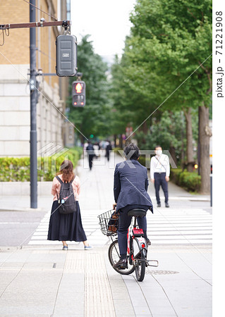 シェアリング自転車に乗って信号待ちしているビジネスマン 71221908