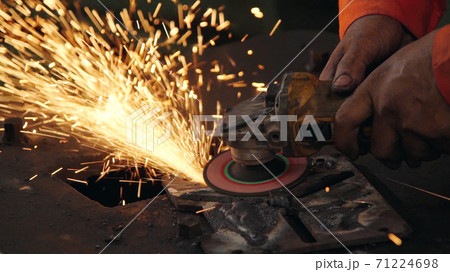 Professional mechanic is cutting steel metal. 71224698